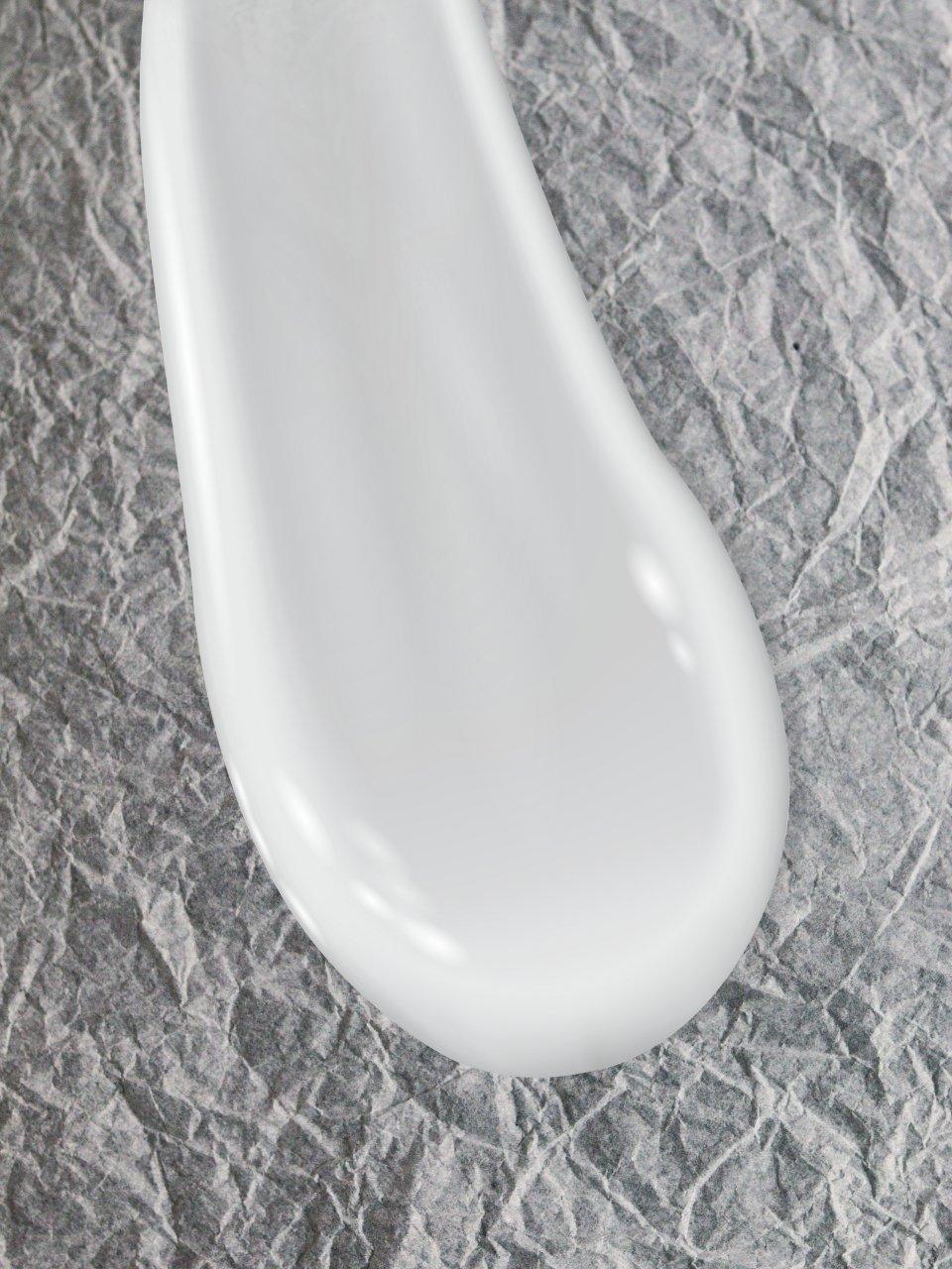 Close-up of Eclat Soin Nourishing Rich Face Cream spread on textured surface